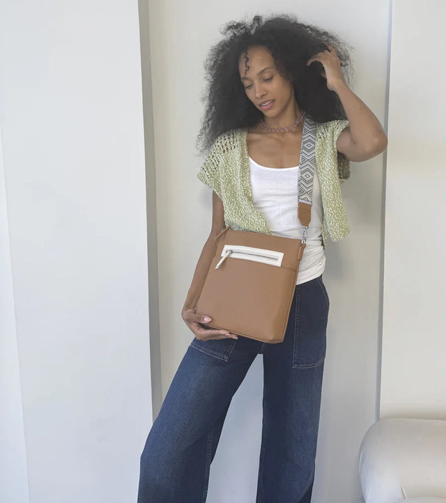 Woman holding a brown clutch against a white background - okotoks hc pharmacy