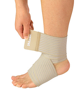 A beige ankle support brace being adjusted on a person's ankle by a hand, shown against a plain white background. - okotoks hc pharmacy