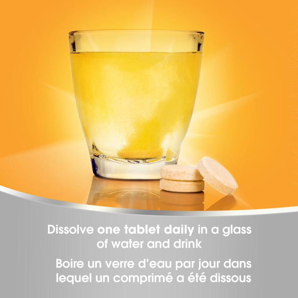 Glass of water with a dissolved tablet and another tablet on an orange background - okotoks hc pharmacy