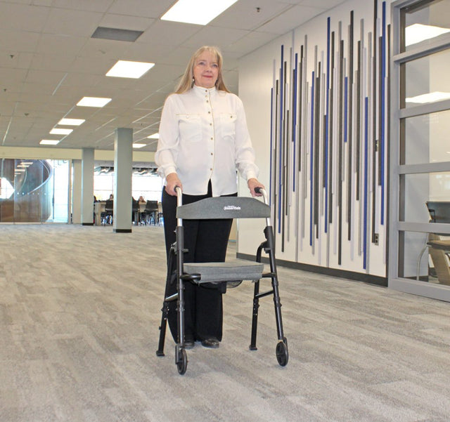 Person using a walker in an indoor setting with a modern design. - okotoks hc pharmacy