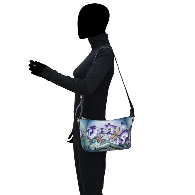 Person wearing a black outfit with a colorful shoulder bag featuring floral designs. - okotoks hc pharmacy