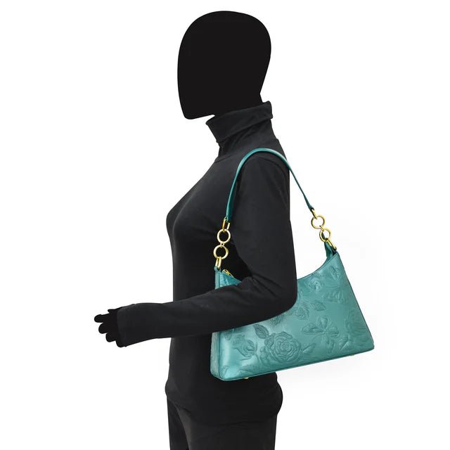 Mannequin wearing a black outfit with a teal handbag on a white background - okotoks hc pharmacy