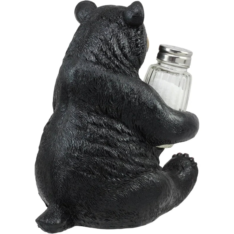 Black bear figurine holding a salt shaker on a white background - okotoks hc pharmacy