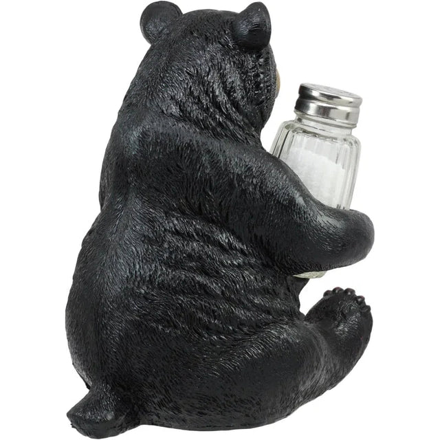 Black bear figurine holding a salt shaker on a white background - okotoks hc pharmacy