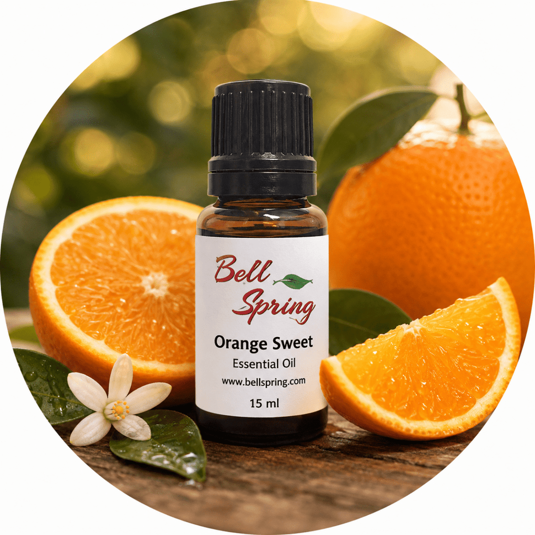 Bell Spring Orange Sweet essential oil bottle with a black cap, set against a circular background of fresh oranges, orange slices, green leaves, and an orange blossom on a wooden surface. - okotoks hc pharmacy