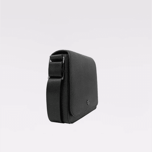 A black textured leather crossbody phone bag with a matching adjustable shoulder strap, shown from a side profile view against a clean white background. - okotoks hc pharmacy