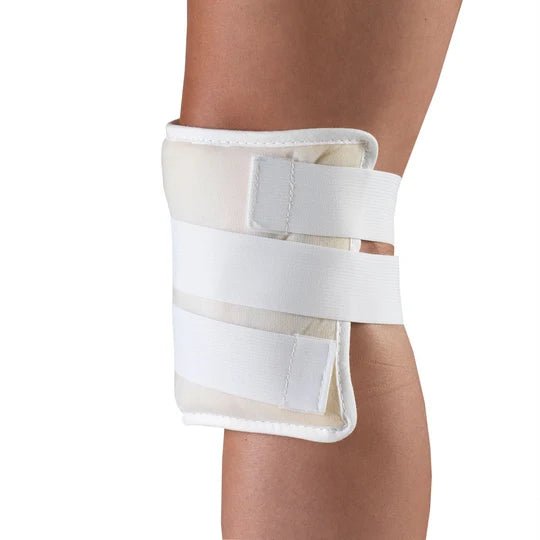 A white knee compress with adjustable straps, shown worn on a person's leg against a plain white background. - okotoks hc pharmacy