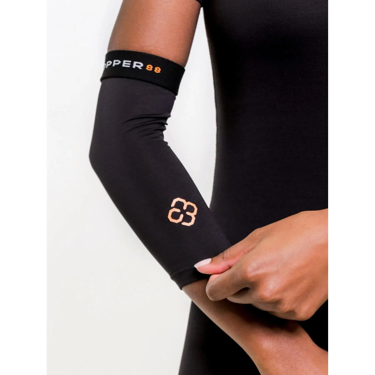 Person wearing a black arm sleeve with a brand logo on a white background - Okotoks HC Pharmacy