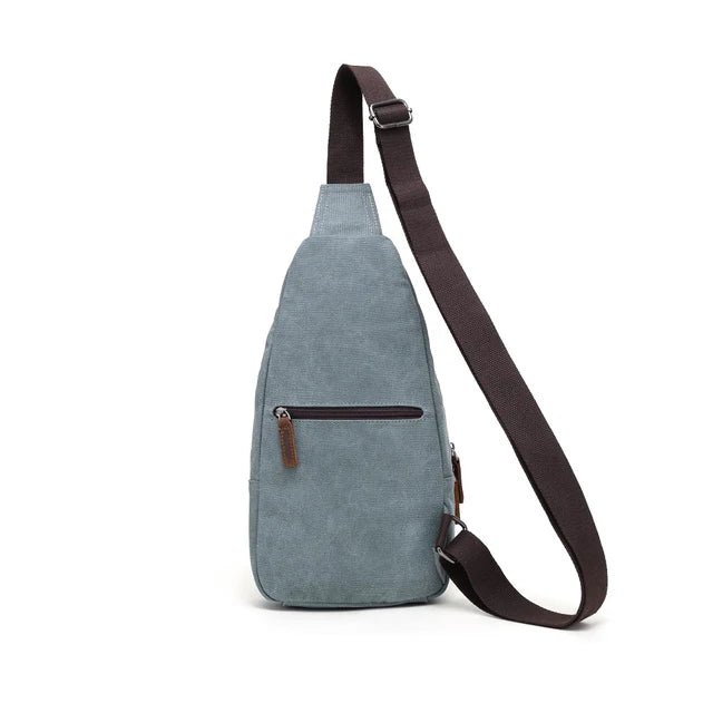 Blue suede sling bag with brown strap on a white background - okotoks hc pharmacy