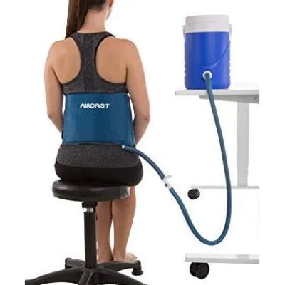 Person wearing a back brace with a cooler on a table in the background - okotoks hc pharmacy