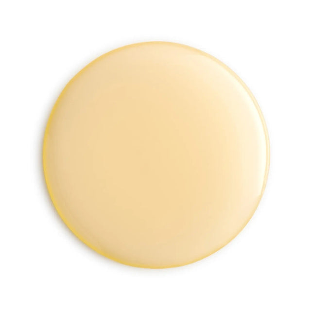 Round beige apricot oil droplet on a white background