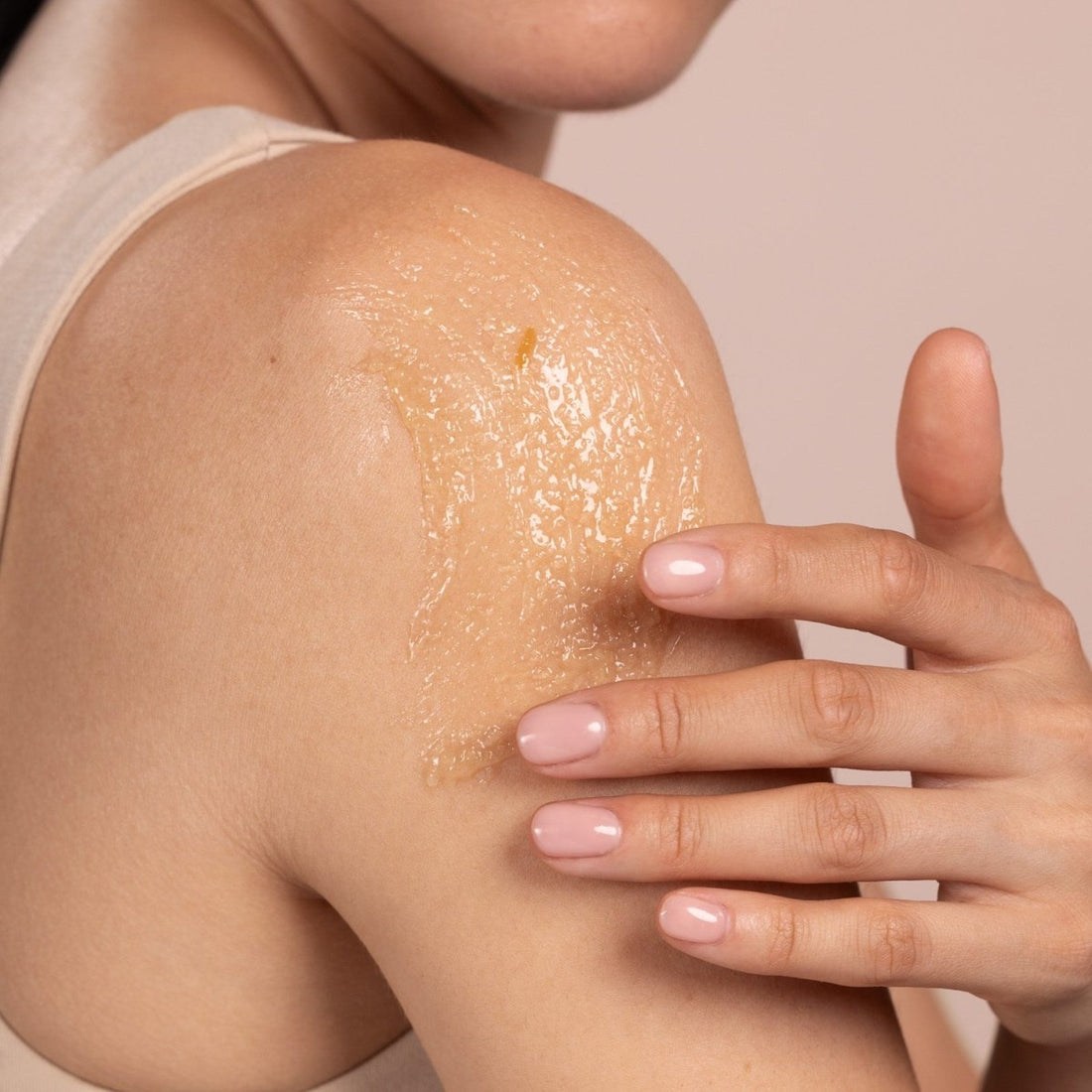 Person applying a skincare product to their shoulder with a hand - okotoks hc pharmacy