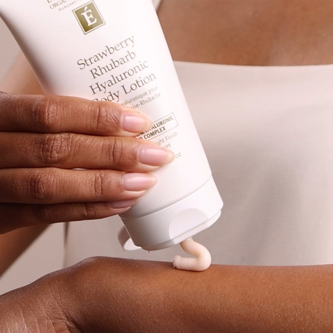 Hand applying strawberry rhubarb hyaluronic body lotion to arm - okotoks hc pharmacy