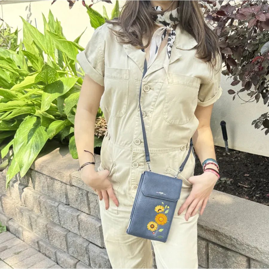 Person wearing a beige outfit with a blue floral purse, standing outdoors near plants. - okotoks hc pharmacy
