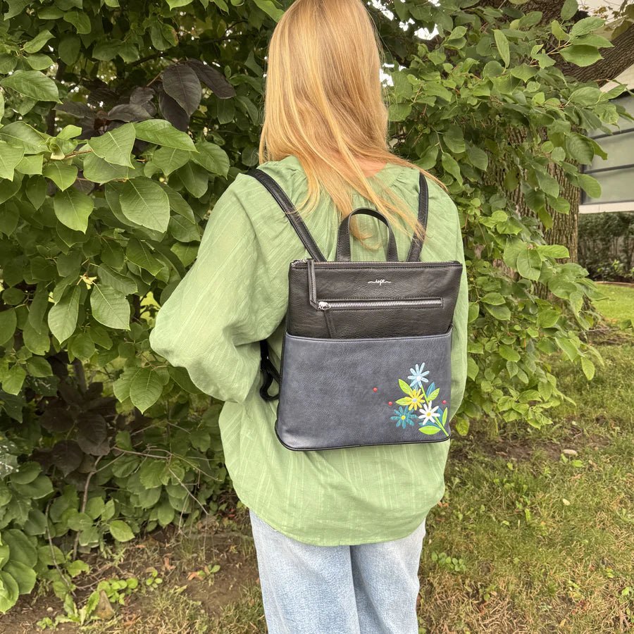 Person wearing a black backpack with floral design outdoors - okotoks hc pharmacy