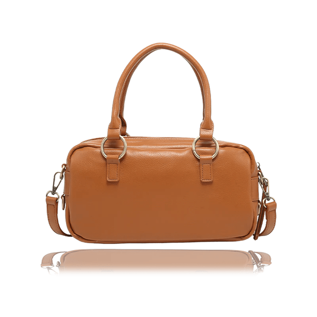 A tan leather handbag with double top handles, gold-tone hardware, and a detachable shoulder strap, shown against a plain white background with a soft reflection below. - okotoks hc pharmacy