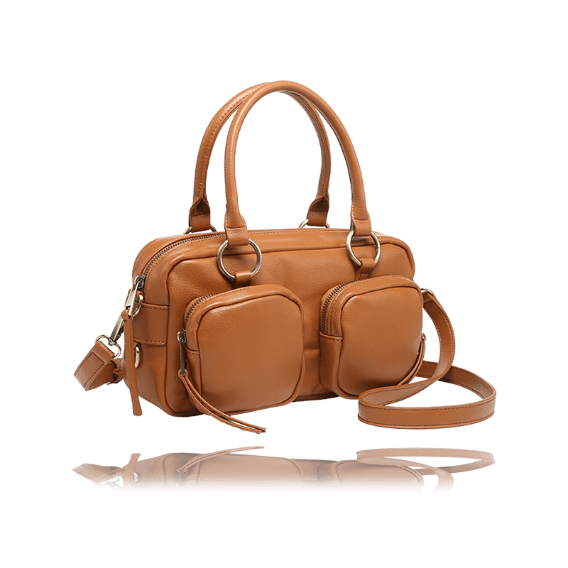 A tan leather handbag with dual top handles, a detachable shoulder strap, and multiple front zippered pockets, shown on a white background with a reflection below. - okotoks hc pharmacy