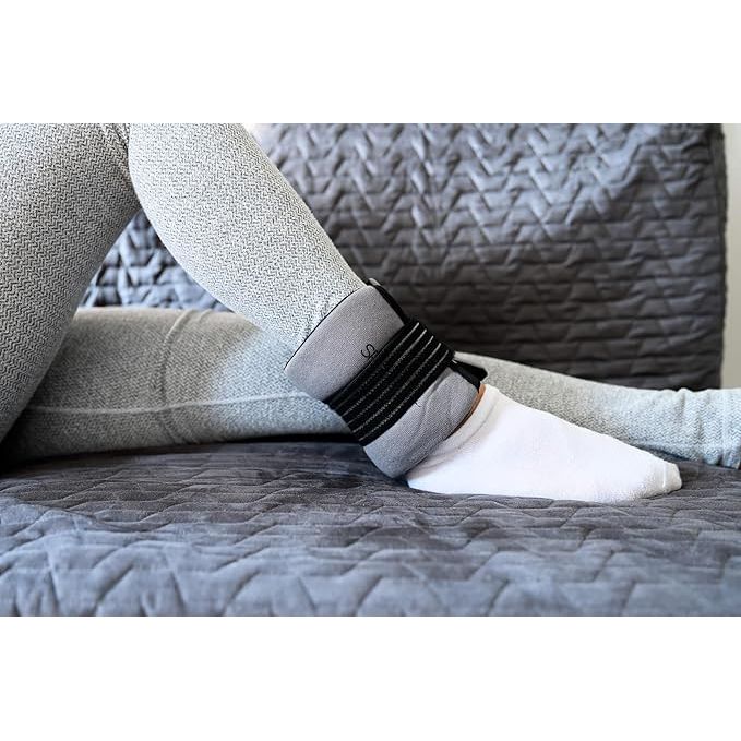 Person wearing a black ankle band on a gray textured surface - okotoks hc pharmacy