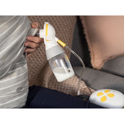 Person using a breast pump, with a blurred background. - okotoks hc pharmacy