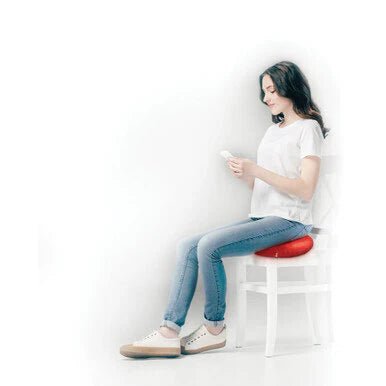 Woman sitting on a white chair with a red cushion, using a smartphone. - okotoks hc pharmacy