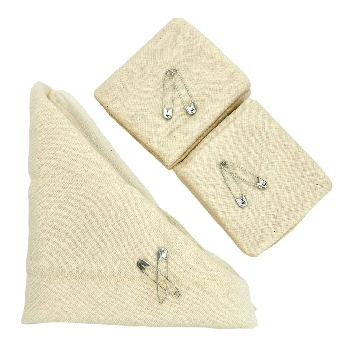 Three beige triangular fabric pads with metal safety pins on a white background - okotoks hc pharmacy