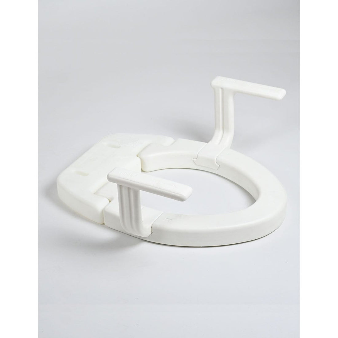 White plastic toilet seat on a light gray background - okotoks hc pharmacy