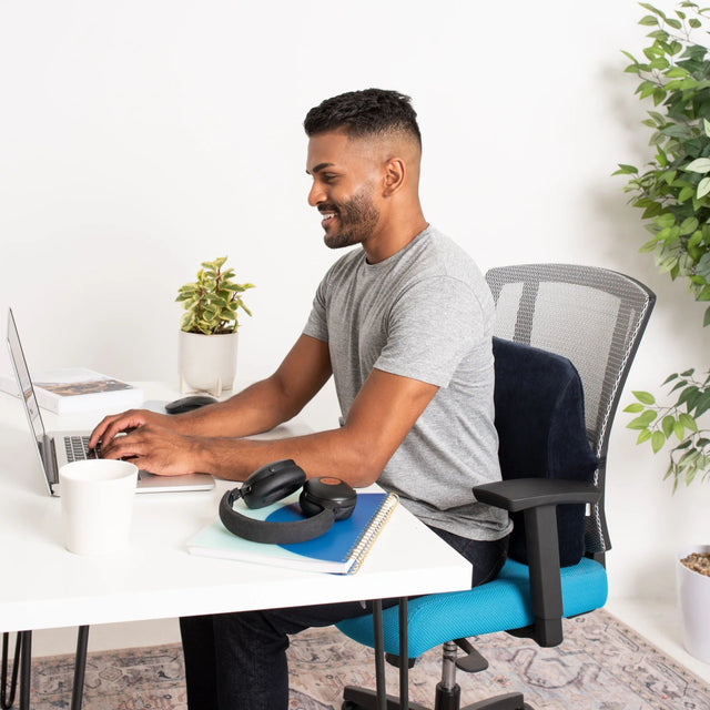Man sitting at a desk with a laptop, wearing headphones, in a home office setting. - okotoks hc pharmacy