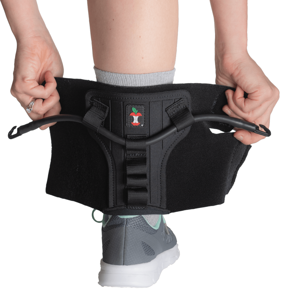 Person wearing a black athletic support brace on a white background - okotoks hc pharmacy