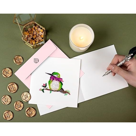 Handwritten card with a colorful bird illustration on a green surface with a candle and wax seals. - okotoks hc pharmacy