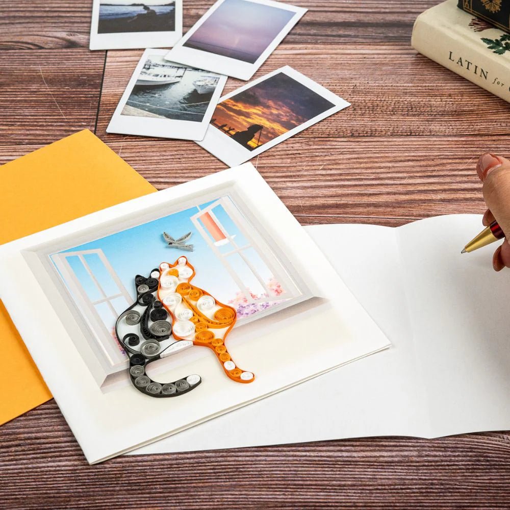Open card with a 3D cat illustration on a wooden table with other books and photos. - okotoks hc pharmacy
