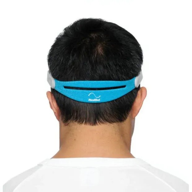 Person wearing a blue and gray headband with a visible brand logo on a white background - okotoks hc pharmacy