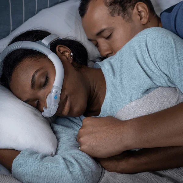 Two people sleeping together with one wearing a CPAP device. - okotoks hc pharmacy
