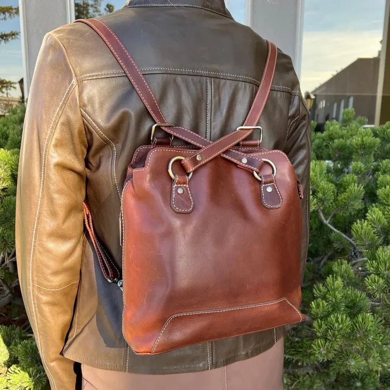 Brown leather backpack worn by a person in a leather jacket outdoors. - okotoks hc pharmacy