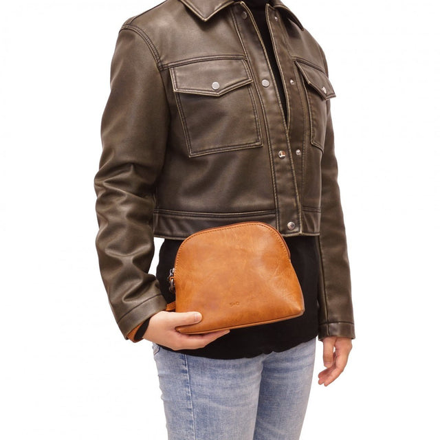 Person wearing a brown leather jacket holding a brown leather pouch on a white background - okotoks hc pharmacy