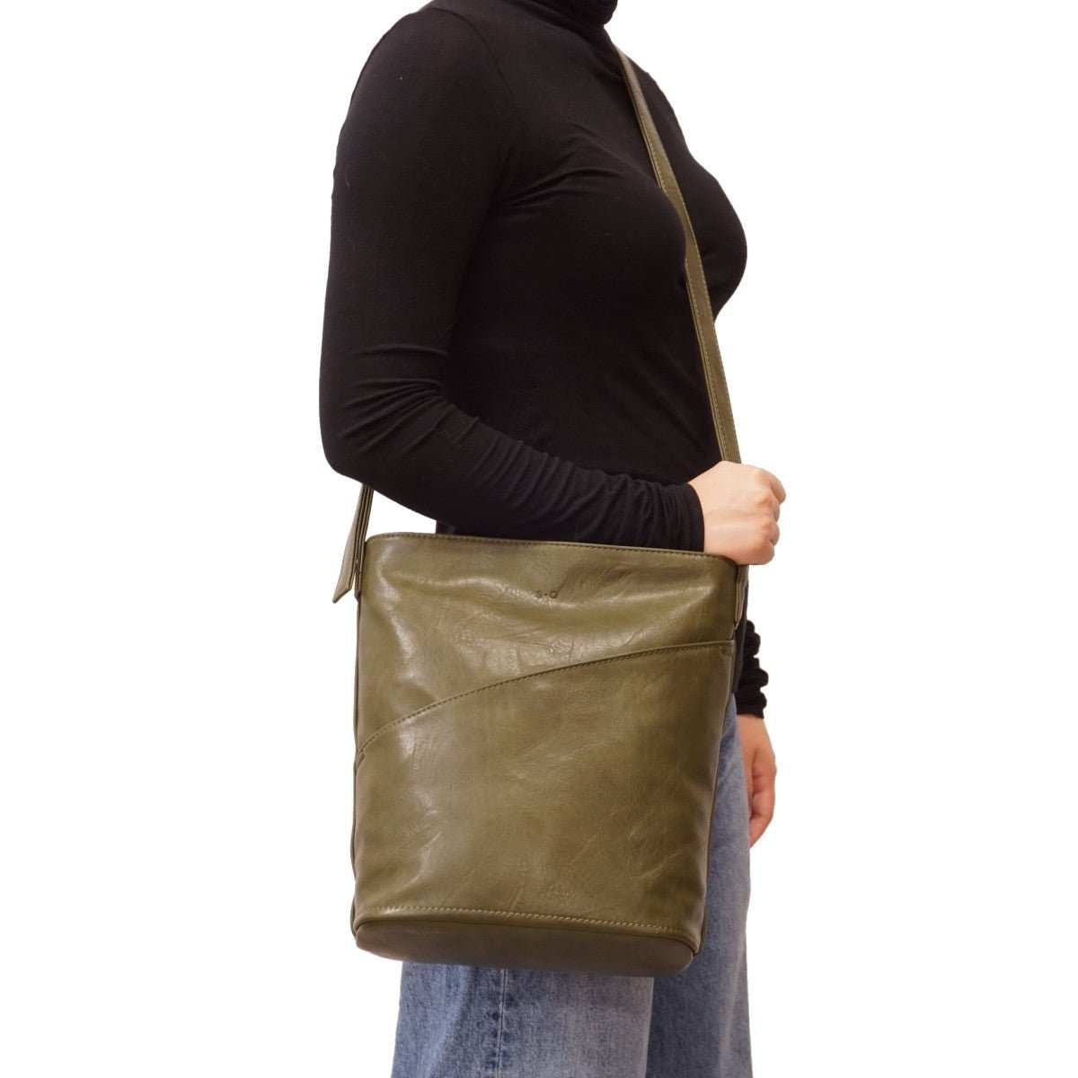 Person holding a green leather bag on a white background - okotoks hc pharmacy