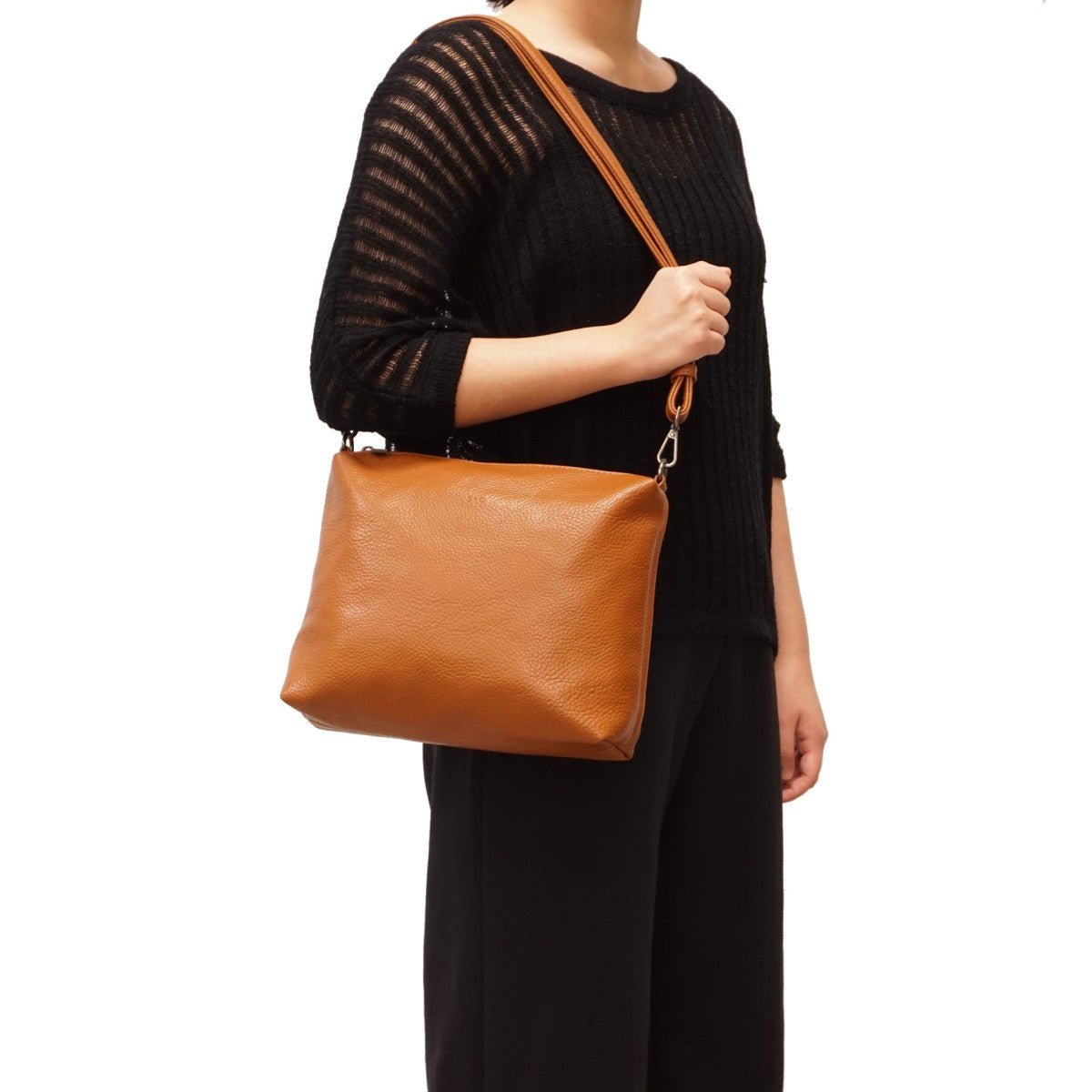 Person wearing a brown leather shoulder bag on a white background - okotoks hc pharmacy