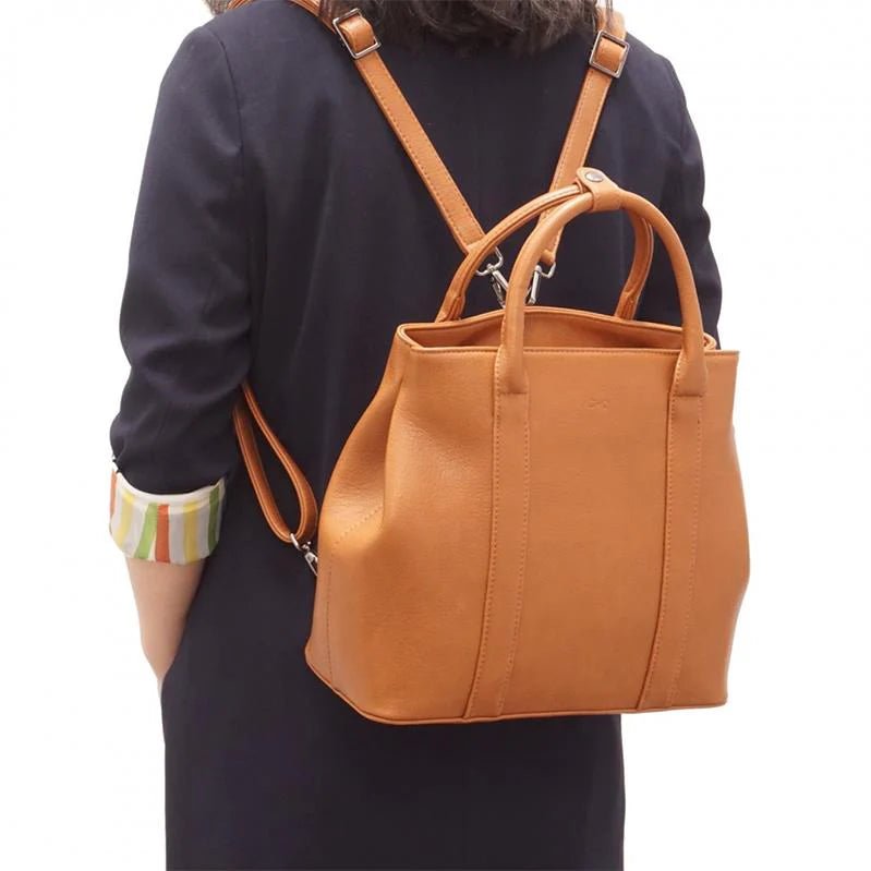 Person wearing a brown leather backpack on a white background - okotoks hc pharmacy