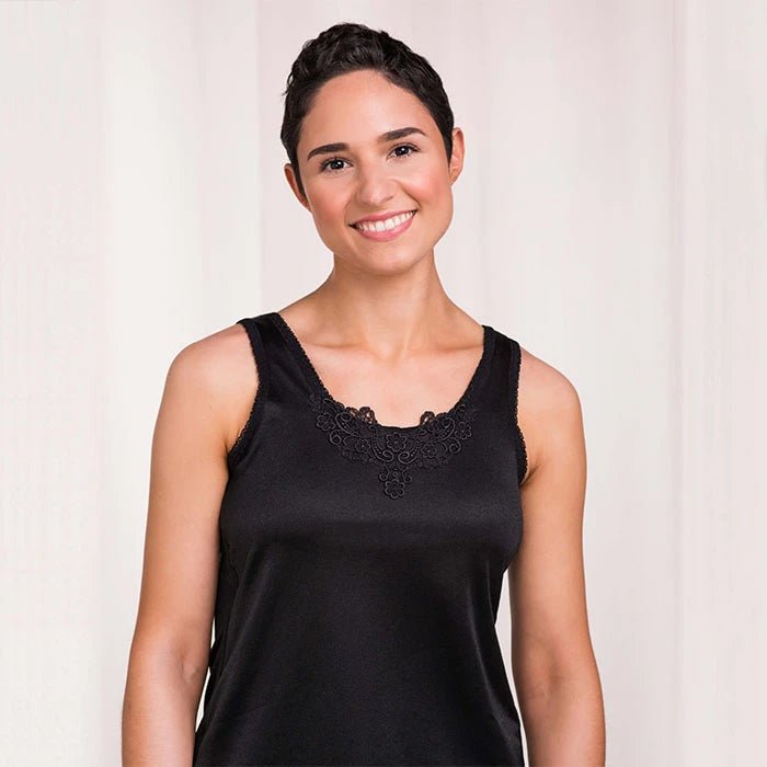 Woman wearing a black sleeveless top with lace details on a plain background - Okotoks HC Pharmacy