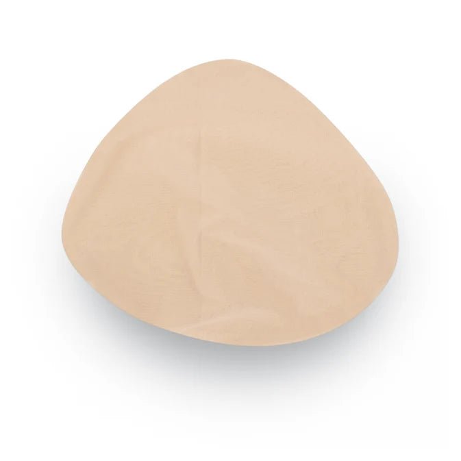 A single beige silicone or latex breast implant cup shown from a top-down view on a white background. - okotoks hc pharmacy