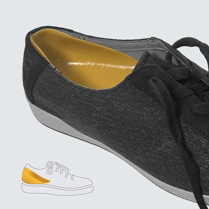 Black sneaker with yellow lining on a light gray background- okotoks hc pharmacy
