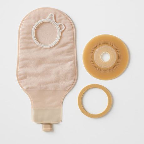 Flat lay of an ostomy two-piece system including a beige pouch, separate flange, and barrier ring on a white background