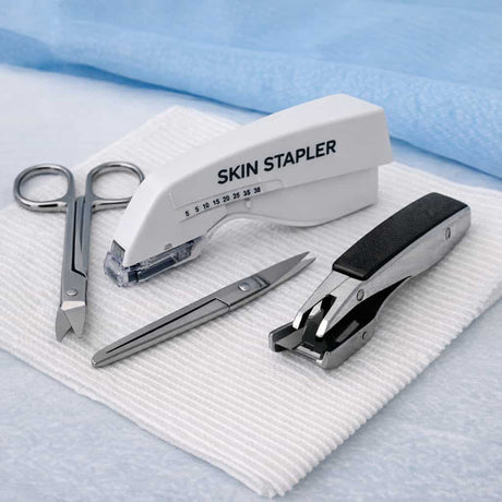 Wound closure and removal tools including sutures, skin stapler, staple remover and suture scissors arranged on sterile gauze