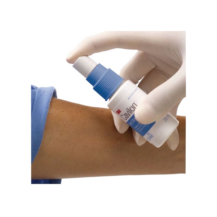 Hand applying a tube of 3M Cavilon to a person's arm on a white background - okotoks hc pharmacy