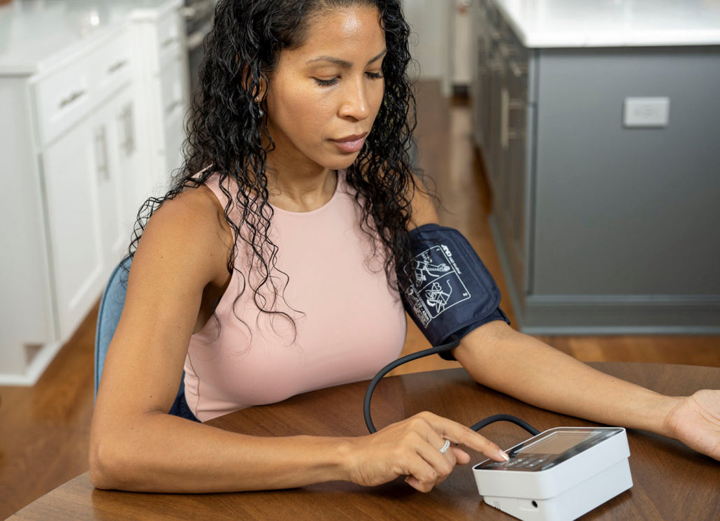 Woman taking her blood pressure at home using a digital device. - okotoks hc pharmacy
