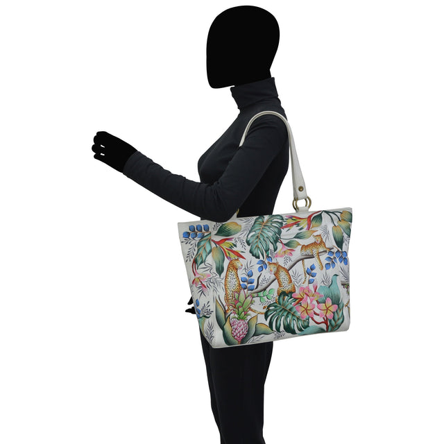 Person holding a floral-patterned handbag on a white background - okotoks hc pharmacy