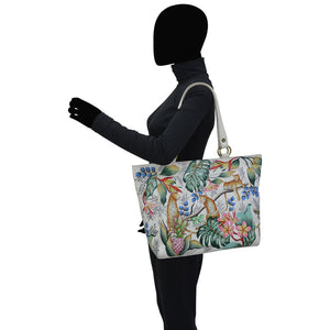 Person holding a floral-patterned handbag on a white background - okotoks hc pharmacy