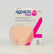 Convatec Aquacel Pro Foam adhesive silicone dressing shown in its retail packaging box, with the peach-colored dressing partially visible in front of the white and pink box. - okotoks hc pharmacy