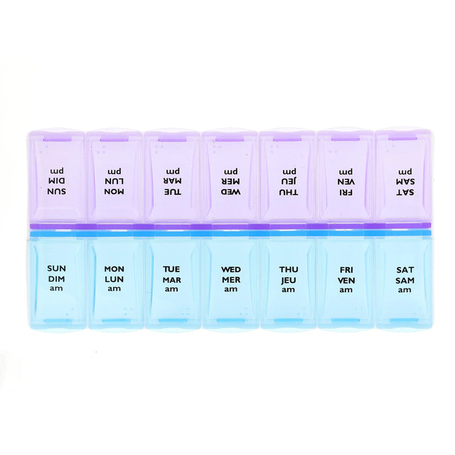 A 7-day weekly pill organizer with translucent plastic compartments. The top row is light purple with black text showing reversed days of the week (SUN, MON, etc. - okotoks hc pharmacy