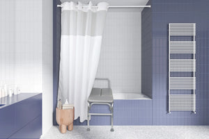 A modern bathroom interior with blue tiled walls, a white shower curtain, a bathtub, a metal examination-style stool, and a white heated towel rail. - okotoks hc pharmacy