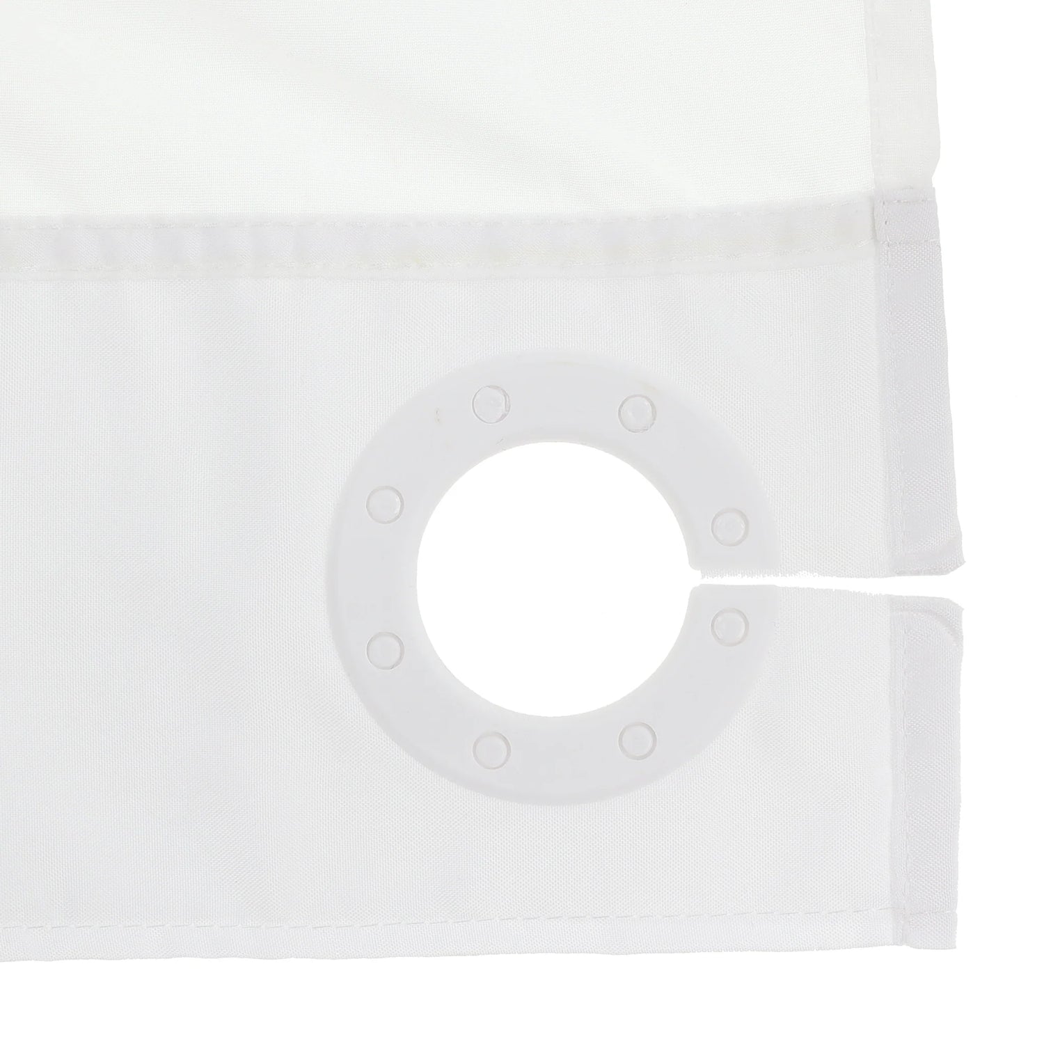 Close-up of a white curtain panel showing the fabric texture, stitched hem, and a circular grommet ring on the corner. - okotoks hc pharmacy